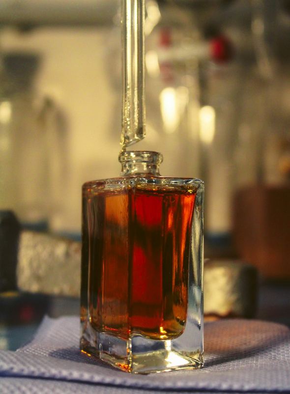Dark oil being drawn with a glass dropper