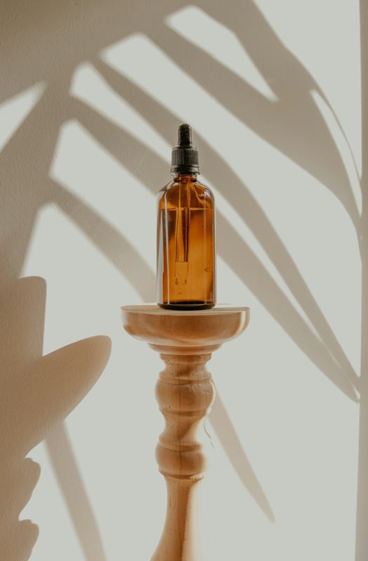 Amber dropper bottle on a wooden stand